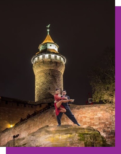 Tanya und Sebastian tanzen schwebend auf der Mauer der Nürnberger Burg.