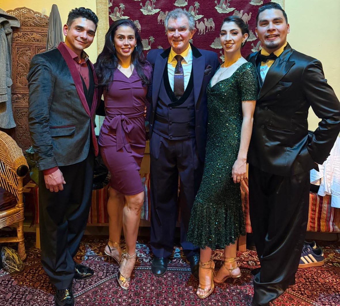 Oscar im Team für Profile Group of five adults posing in formal attire at a party, smiling for the camera in a colorful, decorative room backdrop.